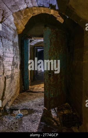 Rusted metal armored door in old abandoned Soviet bunker. Stock Photo