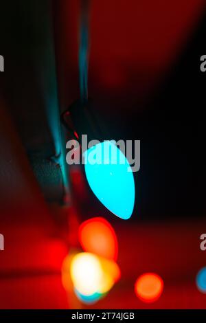 A string of Christmas lights emit a warm light on a December night. Stock Photo