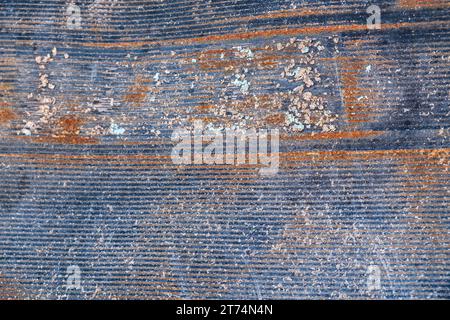 Close up detail of a section of rusted sheet metal. Browns and blue-grey colors with a horizontal texture that runs along the metal. Stock Photo