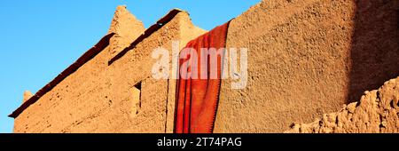 Drying carpet on the earthen walls of the house, Morocco Stock Photo