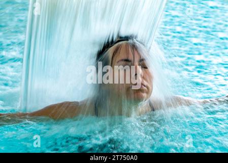 Woman Face in a Waterfall in a SPA Swimming Pool in Long Exposure in Switzerland Stock Photo