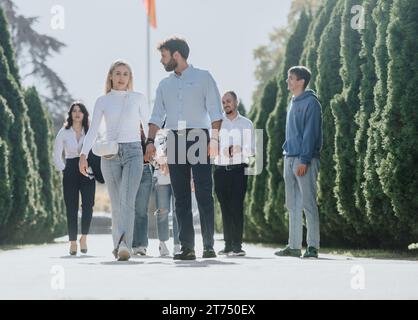 International group of students discuss topics, exchange information, and work on assignments and projects in an inspiring park environment. Stock Photo