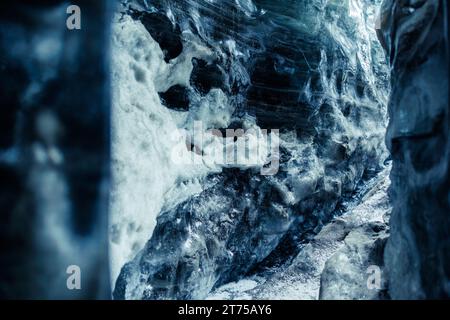 Global warming ice dripping in caves, nordic landscape in iceland. Water melting from massive ice blocks in icelandic vatnajokull iceberg cap crevasse, glacier hiking in winter. Stock Photo