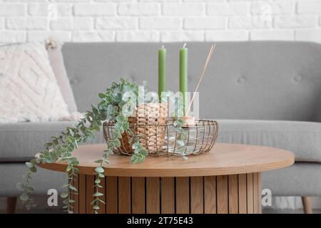 Coffee table with aroma candles and houseplant in bright living room Stock Photo