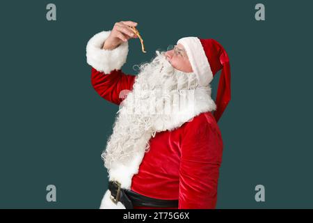 Santa Claus eating tasty pizza on green background Stock Photo