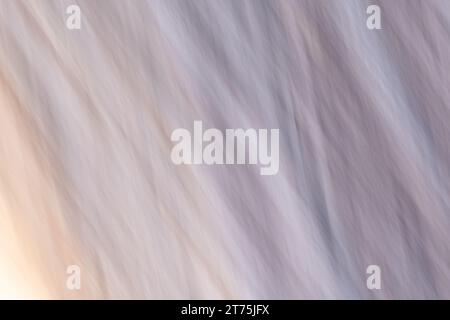 Abstract light painting with a soft, fabric-like  texture and diagonal line pattern, with muted color gradient of blue, yellow, and violet. Intentiona Stock Photo