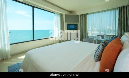 Pattaya Thailand 10 November 2023, A hotel room with bright fresh colors, a minimal style bedroom with ocean view and bathroom connected to bedroom, open bedroom with bathroom Stock Photo