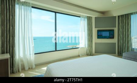 Pattaya Thailand 10 November 2023, A hotel room with bright fresh colors, a minimal style bedroom with ocean view and bathroom connected to bedroom, open bedroom with bathroom Stock Photo