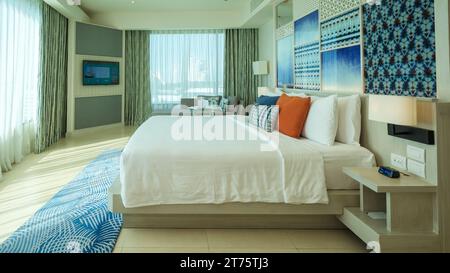 Pattaya Thailand 10 November 2023, A hotel room with bright fresh colors, a minimal style bedroom with ocean view and bathroom connected to bedroom, open bedroom with bathroom Stock Photo