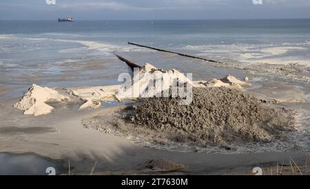 Prerow, Germany. 13th Nov, 2023. The water-sand mixture for sand replenishment shoots out of a pipe on the beach. Since mid-October, the beach and dune have been reinforced with 720,000 cubic meters of sand over a length of almost nine kilometers. The ten million euro project is scheduled for completion at the end of March 2024. Credit: Bernd Wüstneck/dpa/Alamy Live News Stock Photo