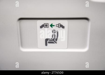 Seatbelt sign on airplane seat Stock Photo