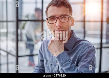 Pensive man in glasses distracted from computer work look in distance thinking or pondering Stock Photo