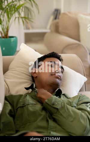 Biracial man lying on sofa and sleeping at home Stock Photo