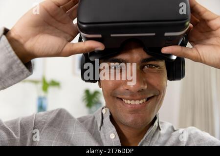 Portrait of happy biracial man using vr headset at home Stock Photo