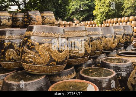 Intricately hand-painted Thai dragon jars display their unique patterns, a testament to Ratchaburi's rich pottery tradition, Ratchaburi, Thailand Stock Photo