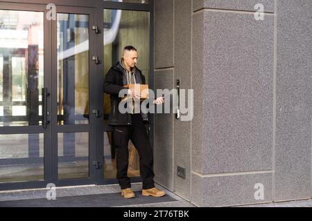 Man uses smartphone to open the door of his house Stock Photo