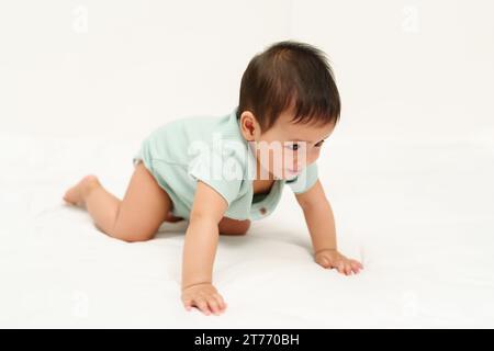 happy infant crawling on floor inside a baby playpen Stock Photo