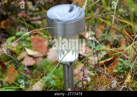 A solar power lamp at summer cottage garden during autumn in Finland. Autumn leaf color (ruska in Finnish) is a phenomenon that affects the green leaves of many deciduous trees. Stock Photo