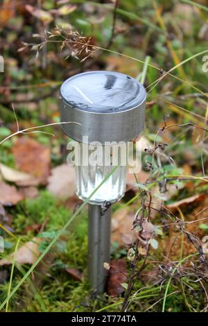 A solar power lamp at summer cottage garden during autumn in Finland. Autumn leaf color (ruska in Finnish) is a phenomenon that affects the green leaves of many deciduous trees. Stock Photo