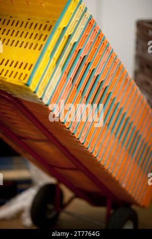 Close up of a stack of plastic crates leaning on a lifting cart Stock Photo