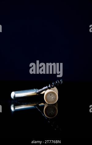 Close up of a silver corkscrew and synthetic cork on a marble surface Stock Photo