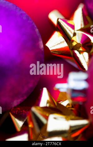 Extreme close up of red and purple Christmas baubles and gold bows Stock Photo