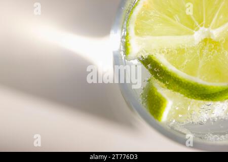 Extreme close up of a glass of sparkling water with sliced lime Stock Photo