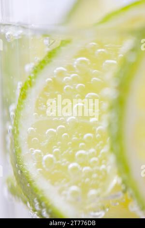 Extreme close up of slices of lime floating in sparkling water Stock Photo