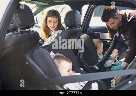 Man Fastening Baby Boy Safety Seat in Car Stock Photo