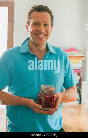 Man Holding Mason Jar with Cherry Vodka Stock Photo