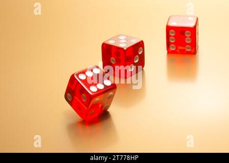 detail of three red dice on golden background Stock Photo