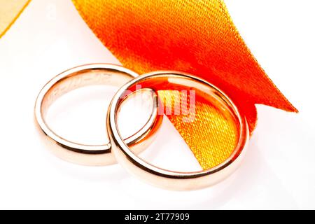 gold wedding rings near ribbon on white background Stock Photo