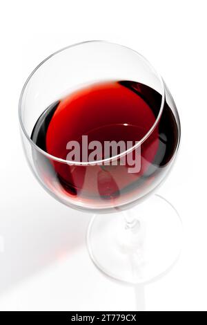 top of view of red wine glass under daily light on white table Stock Photo