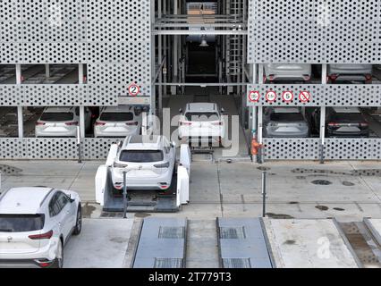 YANTAI, CHINA - NOVEMBER 13, 2023 - AGV (Automated Guided Vehicle) transfers commercial vehicles from the warehouse to the handover area at the commer Stock Photo