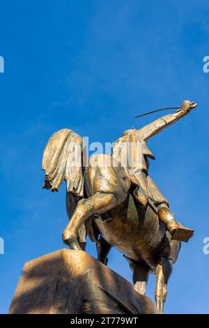 Low-angle view of Emir Abdelkader's statue against a blue sky in Algiers City. Stock Photo