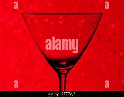 silhouette of empty cocktail glass  on red light tint bokeh background Stock Photo