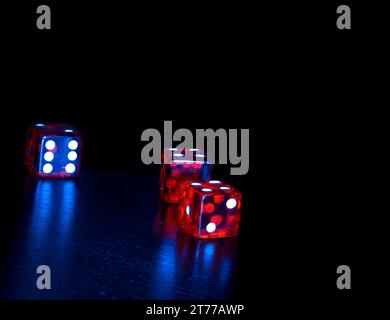 three red dice on old wood black table on light blue tint background with space for text Stock Photo