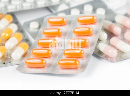 medicine pills and capsules packed in blisters on white table Stock Photo
