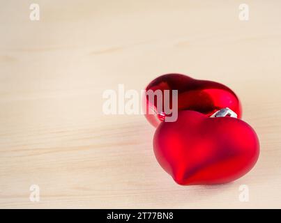 two red ceramic hearts on love letter paper background 6742207