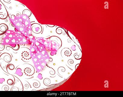 gift box with ribbon on red background with space for text, concept of valentine day Stock Photo