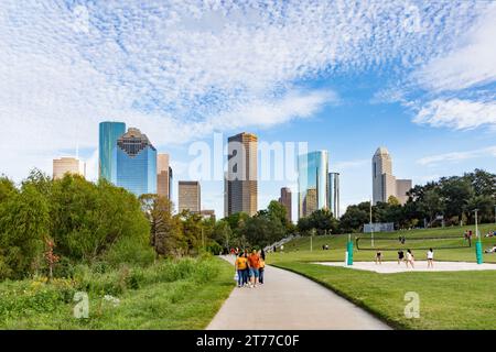 Houston, USA - October 22, 2023: people enjoy scenic view to skyline of Houston, Texas in morning light from Buffalo bayou park. Some play volleyball. Stock Photo