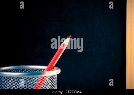 back to school, red pencil in container against empty blackboard for text Stock Photo