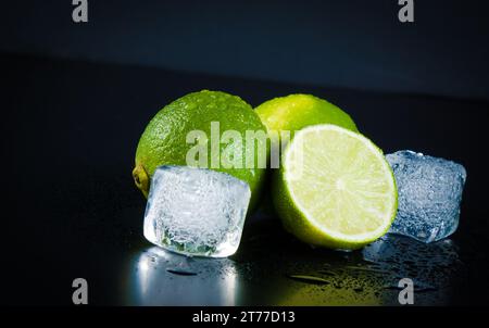 Lime with ice cubes on black background with space for text Stock Photo