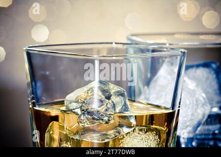 close-up of whiskey glasses on blue light and bokeh background Stock Photo