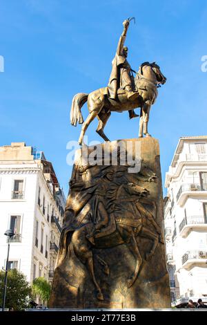 Low-angle view of Emir Abdelkader's statue against a blue sky in Algiers City. Stock Photo