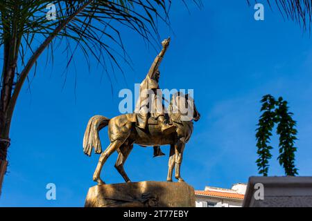 Low-angle view of Emir Abdelkader's statue against a blue sky in Algiers City. Stock Photo