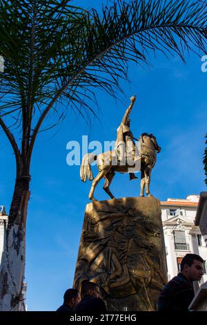 Low-angle view of Emir Abdelkader's statue against a blue sky in Algiers City. Stock Photo