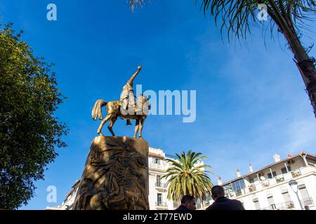 Low-angle view of Emir Abdelkader's statue against a blue sky in Algiers City. Stock Photo