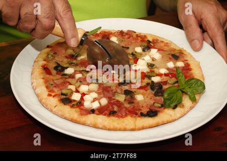 Cutting a pizza. Stock Photo