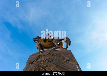 Low-angle view of Emir Abdelkader's statue against a blue sky in Algiers City. Stock Photo